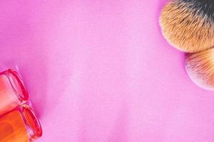 Flatlay of make up and beauty products on a pink background. photo