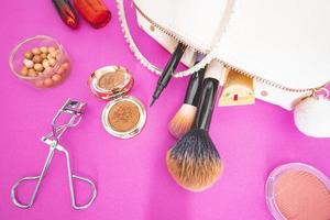 Flatlay of make up and beauty products on a pink background. photo