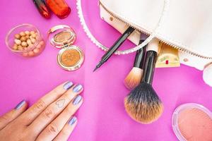 Flatlay of make up and beauty products on a pink background. photo