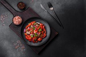 A salad of baked mushrooms, tomatoes, onions, parsley, spices and herbs photo