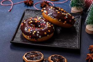 Pastries concept. Donuts with chocolate glaze with sprinkles, on a dark concrete table photo