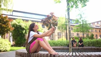 Woman sitting outside using phone video