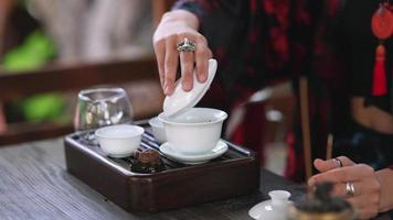 Tea ceremony performed by a young brunette woman on outdoor terrace video