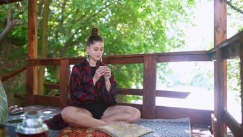 Tea ceremony performed by a young brunette woman on outdoor terrace video