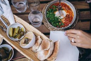 Shakshuka, Fried Eggs in Tomato Sauce on the Table photo