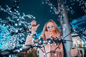 Girl posing against the background of decorated trees photo