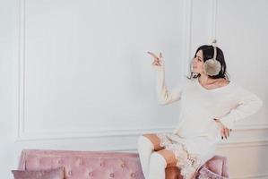 Young lady white caucasian woman in white dress posing in room photo