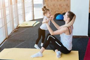 Mom and daughter together perform different exercises photo