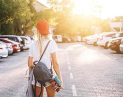 Young girl with a skateboard on a car park. photo