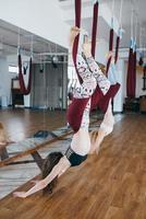 Young girls do aerial yoga in the gym photo