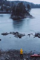 The guy is standing at the frozen lake photo