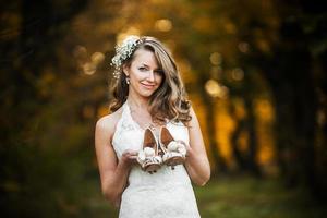 bride holding wedding shoes photo