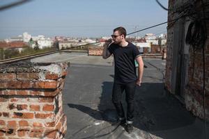 The man in the authentic boots and jeans selvedge on the roof of the building in the old town photo