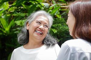 hija que cuida a la anciana madre asiática, ambas ejercidas en el jardín delantero. que sea sana, fuerte, una familia feliz. concepto de cuidado de personas mayores en edad de jubilación foto