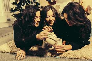 Beautiful girl eating Christmas cookies and drink tea while lying on a carpet. Decorative vintage apartment. photo