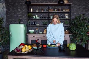 Young beautiful blonde takes on videos as she cooks in the kitchen photo