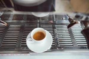 close-up view of glass cup with cappuccino and coffee machine photo