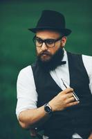 man with a beard smokes electronic cigarette photo