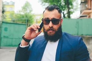 Bearded businessman looking at phone photo