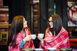 Two young and beautiful girls gossiping photo