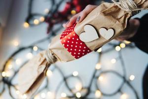 niña sosteniendo un regalo de navidad en la mano foto