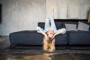 Woman enjoying on a couch with head upside down. photo