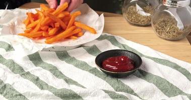 Vidéo 4k, séquences vidéo de nourriture tournées, manger des frites de pommes de terre. mains prenant des frites et les trempant dans de la sauce tomate ou du ketchup. concept de restauration rapide de collation de fête. video