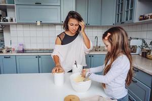 mamá le enseña a su pequeña hija a cocinar foto