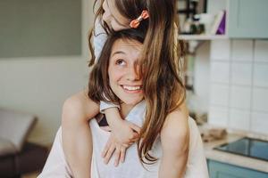 beautiful little daughter piggybacking on her happy mother photo