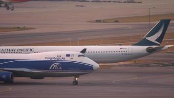 hong kong 07 de noviembre de 2019 - cathay pacific airbus a330 b lae rodando antes de la salida y cargologicair boeing 747 g claa rodando después del aterrizaje. aeropuerto chek lap kok, hong kong video