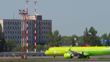 novosibirsk, federación rusa 12 de junio de 2022 - posibilidad remota de las aerolíneas airbus s7 que se dirigen a la terminal en el aeropuerto de tolmachevo. vista de la plataforma del aeropuerto video
