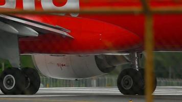 PHUKET, THAILAND DECEMBER 5, 2016 - AirAsia Airbus HS BBN taxiing to the start before departure, close up of wing, engine and gear