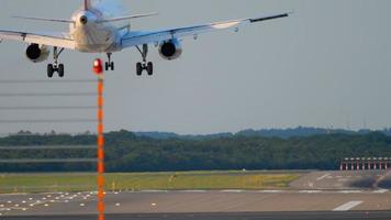 Airplane landing at 05R runway Dusseldorf airport, evening sunset rays video
