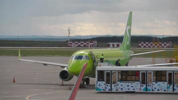 KAZAN, RUSSIAN FEDERATION SEPTEMBER 14, 2020 - passengers disembarking from S7 Airlines Embraer E170 VQ BYV after its arrival to Kazan International airport, view from Control Tower video