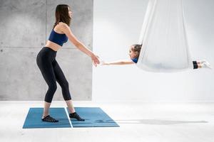 Mom and Daughter are doing yoga. Family in a gym. photo