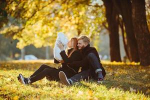 young family and newborn son in autumn park photo