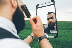 hombre barbudo preparándose para afeitarse en el campo foto