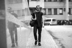 The man in the authentic boots and selvedge jeans  on a background of old city photo