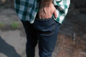Man holding his hand in the back pocket of his jeans photo