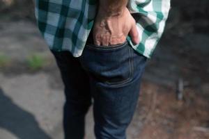 hombre sosteniendo su mano en el bolsillo trasero de sus jeans foto