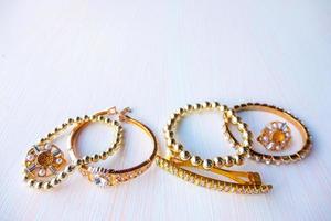 a lot of gold costume jewelry with different materials on a white background. Copy space photo