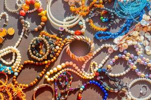 a lot of costume jewelry with different materials on a black background photo