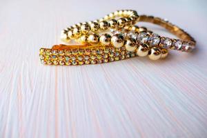 a lot of gold costume jewelry with different materials on a white background. Copy space photo