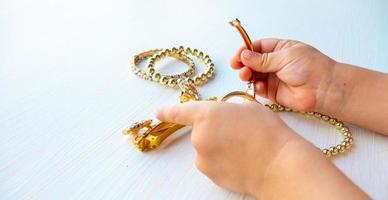 childrens hands play with gold jewelry and bijouterie, on white background. concept of womens happines photo