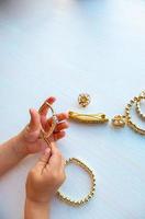 childrens hands play with gold jewelry and bijouterie, on white background. concept of womens happines photo