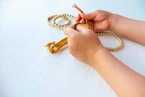 childrens hands play with gold jewelry and bijouterie, on white background. concept of womens happines photo