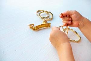 childrens hands play with gold jewelry and bijouterie, on white background. concept of womens happines photo