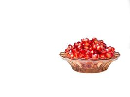 Plate with pomegranate seeds on a white background photo