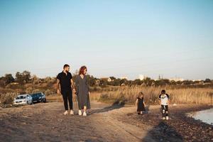 una familia de 4 personas caminando sobre una tierra foto