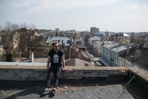 The man in the authentic boots and jeans selvedge on the roof of the building in the old town photo